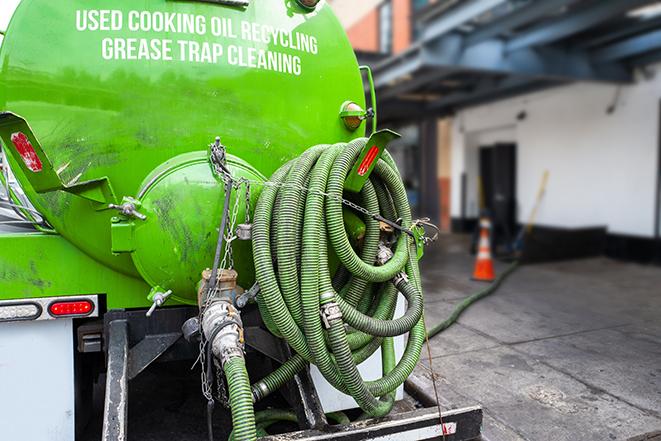 a technician pumping a grease trap in a commercial building in Berea